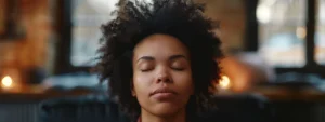 a person sitting in meditation with eyes closed and a serene expression on their face.