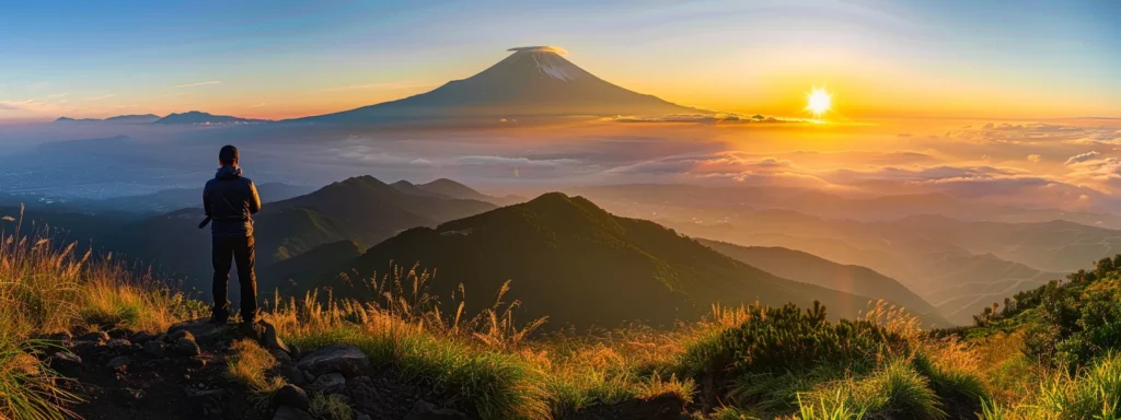 a person standing proudly on top of a mountain peak, basking in the radiant glow of a sunrise.