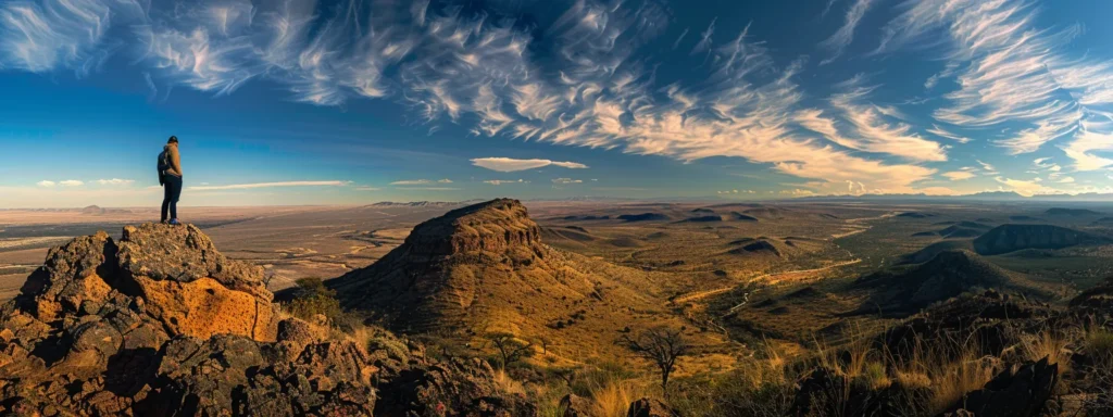 a determined individual standing atop a mountain peak, gazing out at a vast landscape, symbolizing the power of motivational theories to drive success.