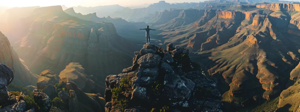 a person standing confidently atop a mountain peak, arms outstretched, with a breathtaking view of a vast, majestic landscape below.