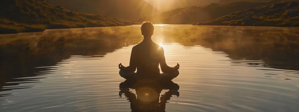 a serene person practicing heartmath techniques by quietly meditating near a tranquil lake at sunrise to improve emotional wellbeing.