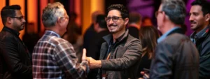 an image of a confident entrepreneur shaking hands with a diverse group of professionals at a networking event, exuding charisma and influence.