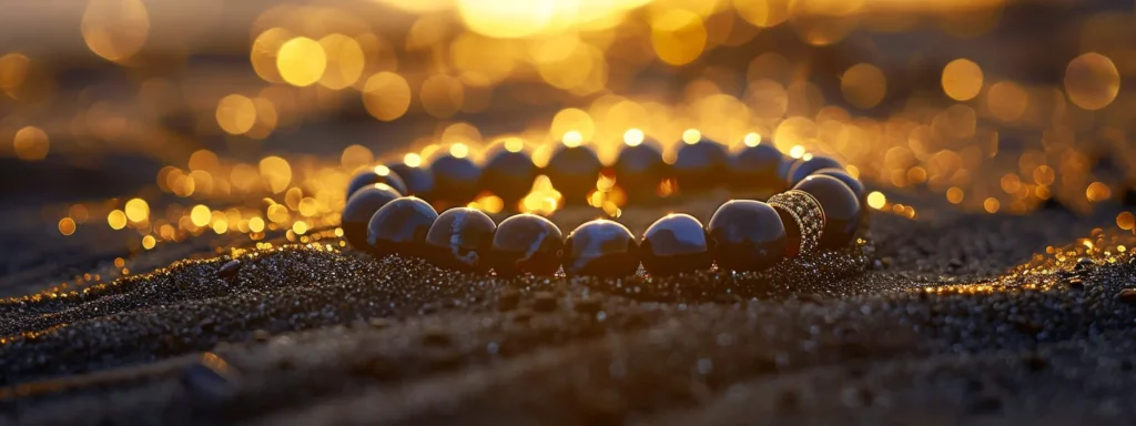 a sleek, polished onyx bracelet resting on a bed of shimmering black sand under soft, golden sunlight.